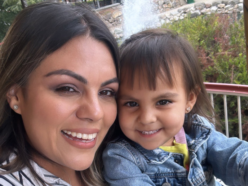 Smiling woman and child outdoors.