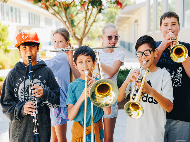 Children playing musical instruments outdoors