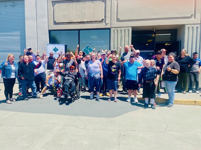 Group of people smiling outside a building.